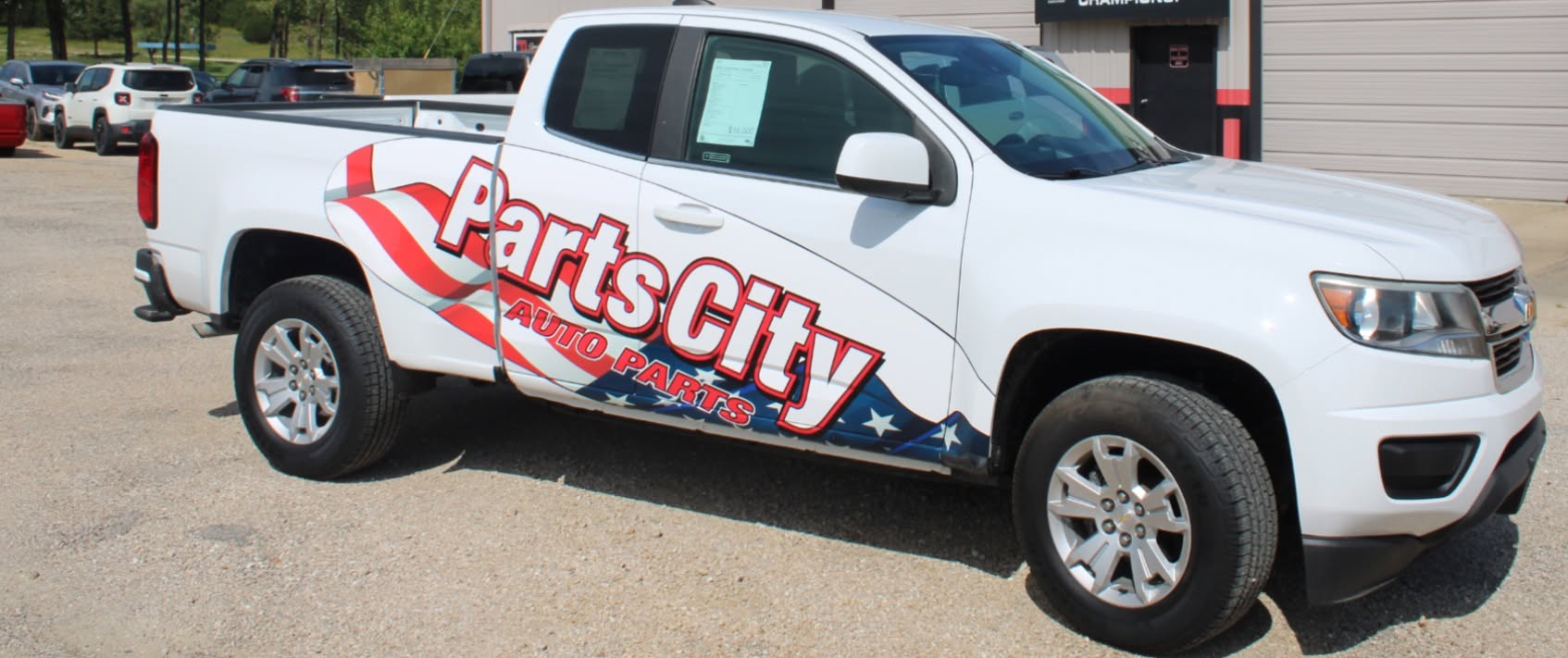 White Parts City Auto Parts pickup truck with custom patriotic vinyl vehicle wrap installed by Pro DeZigns in Columbia Missouri.